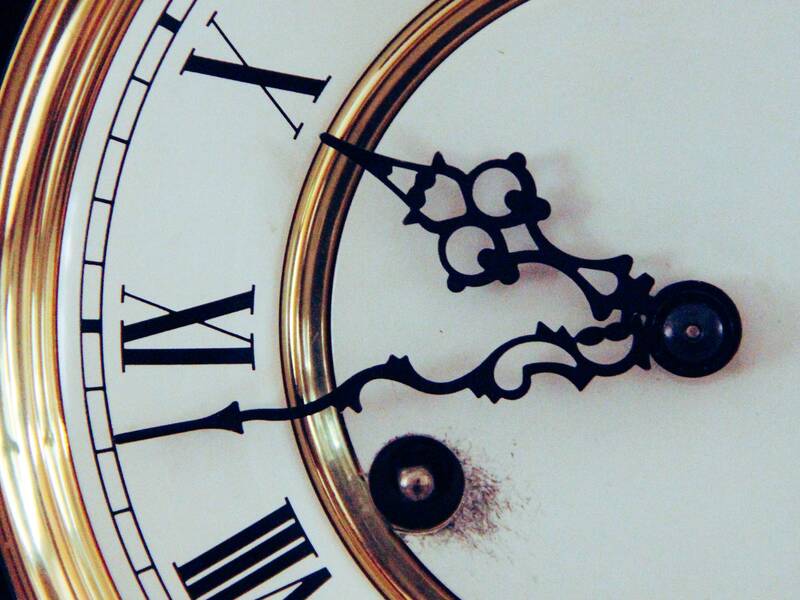 Eine alte Uhr mit alten römischen Ziffern und goldenem Rand. Die Uhr ist nur zur Hälfte abgebildet. 