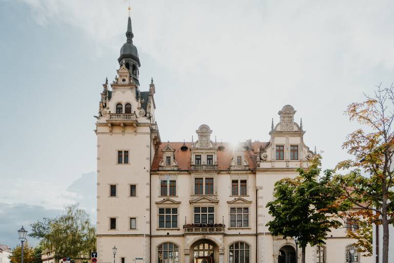 Eine Kirche von Vorne. Auf der linken Seite des Gebäudes ist der hohe Kirchturm. An der Front ist der große Eingang. 
